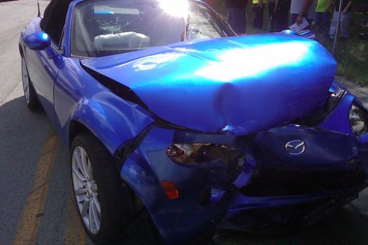 A blue sports car has been damaged in a crash.