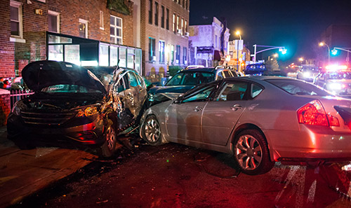A multiple car crash on a city street at night.