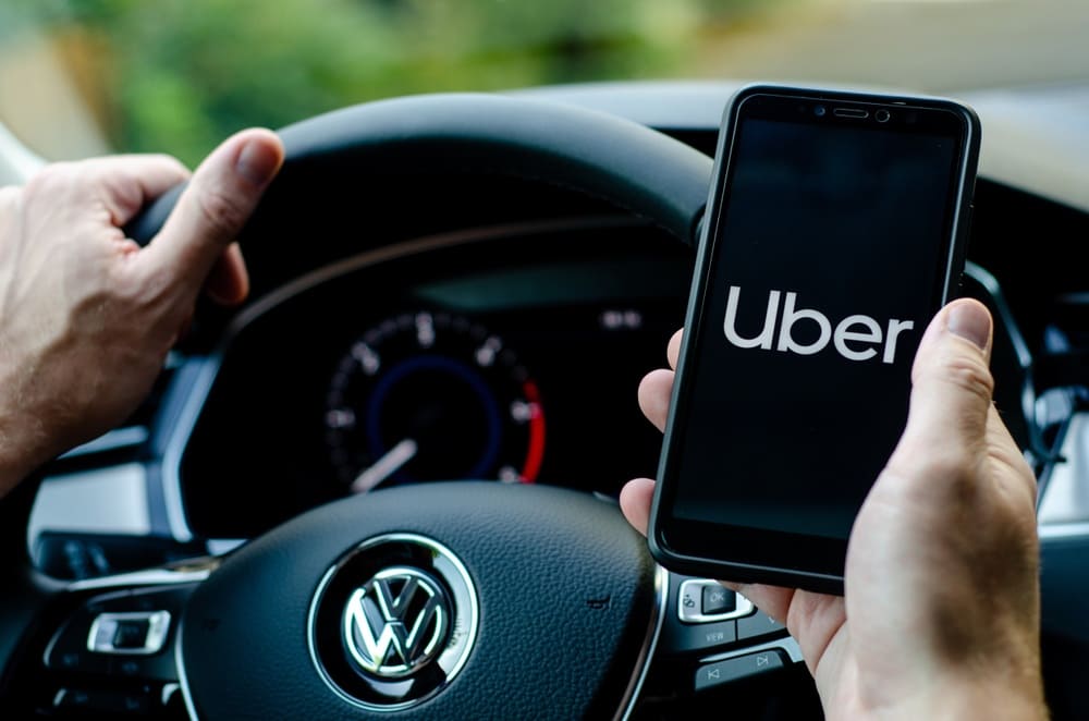 Uber driver holding smartphone in Volkswagen car